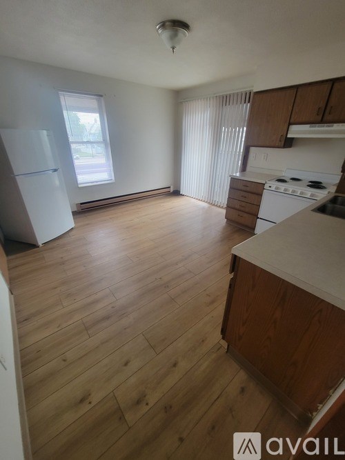 A kitchen with wooden floors and white appliances.