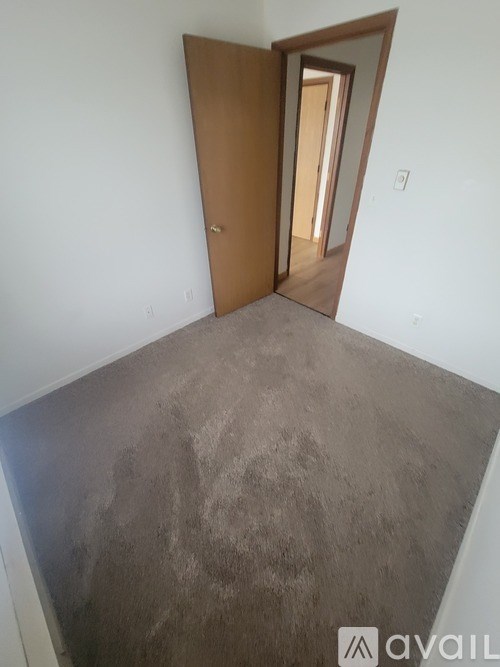 A room with a brown door and a grey floor.