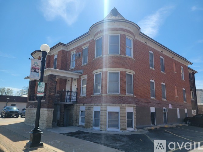 A red brick building with a white sign in front of it.