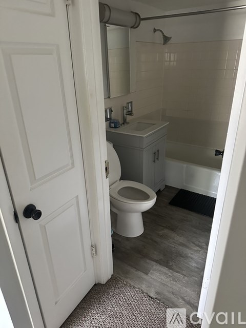 A white toilet is in a small bathroom with a white door.