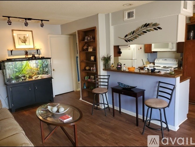A living room with a fish tank, a bar area, and a dining table.