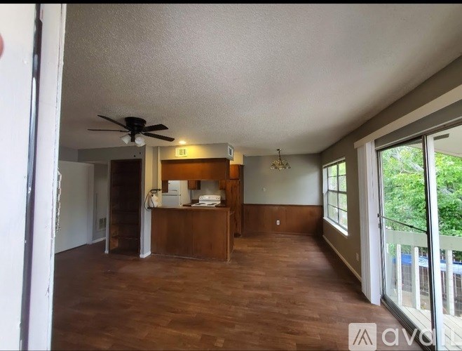 A room with a ceiling fan and wooden flooring.