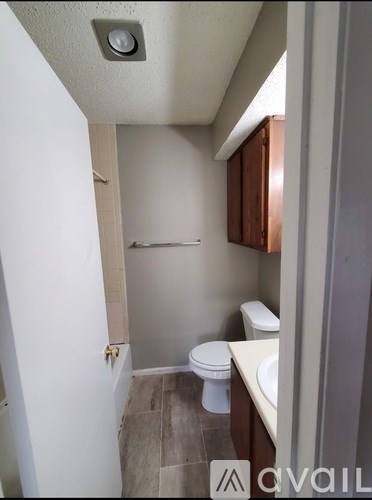 A small bathroom with a toilet, sink and a shower.