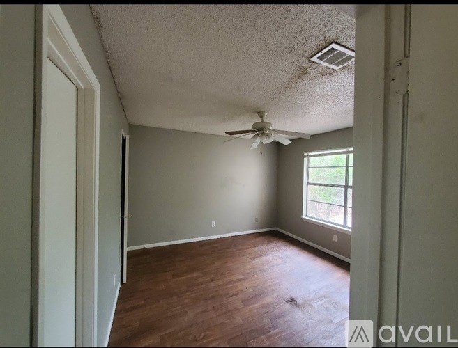 A room with a ceiling fan and a window.