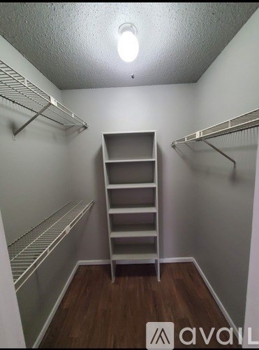 A small, empty room with a wooden floor and white walls.