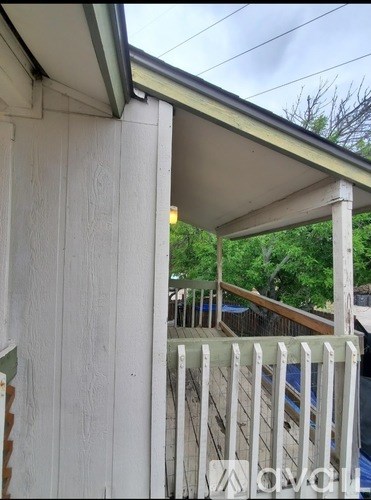 A white wooden fence is attached to a house.