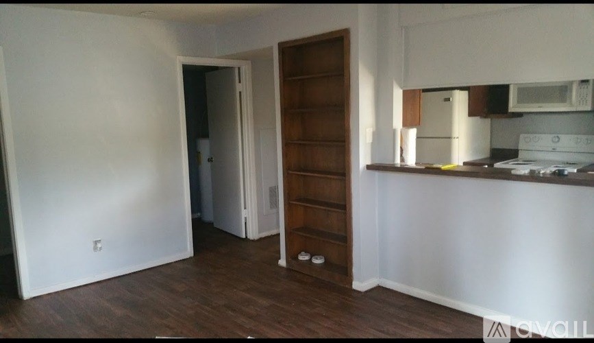 A kitchen area with a white counter and a microwave.