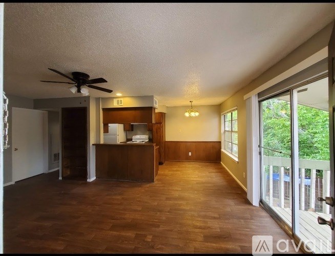 A living room with a ceiling fan and sliding glass doors.