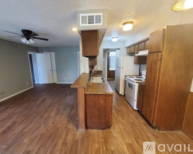 A kitchen with wooden floors and a center island with a sink.