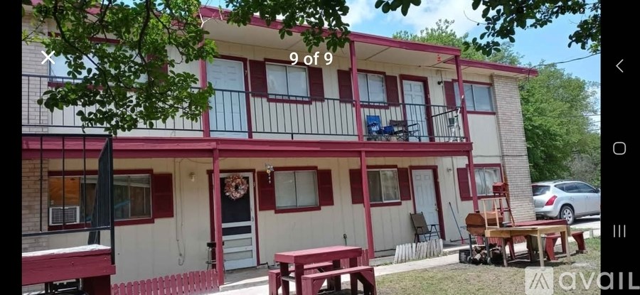 A red and white house with a balcony and a porch.