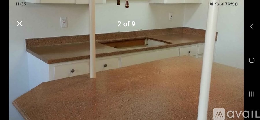 A kitchen counter with a brown countertop and white cabinets.