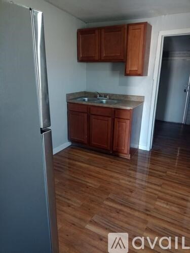 A kitchen with wooden cabinets and a refrigerator.