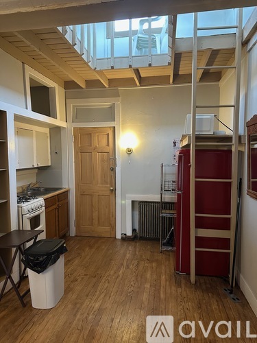 A small kitchen with wooden floors and a red cabinet.