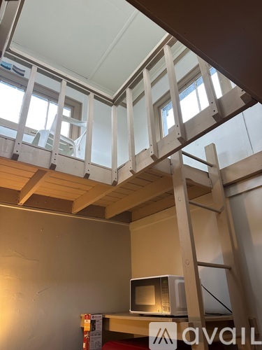 A room with a microwave on the counter and a ladder in the foreground.