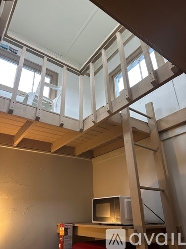 A room with a microwave on the counter and a ladder in the foreground.