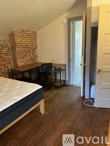 A bedroom with a brick wall and a bed.