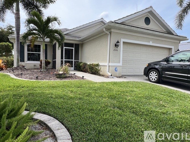 A house with a black car parked in front of it.