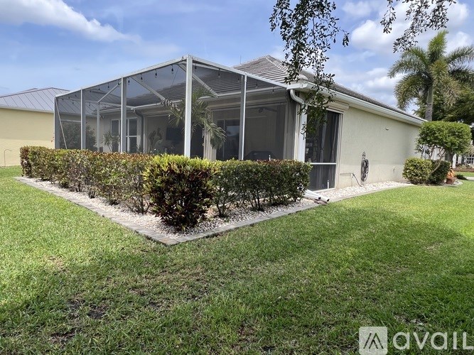 A house with a glass wall and a hedge in front.