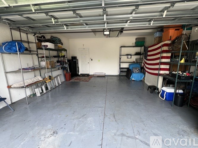 A garage with a white floor and a white door in the background.