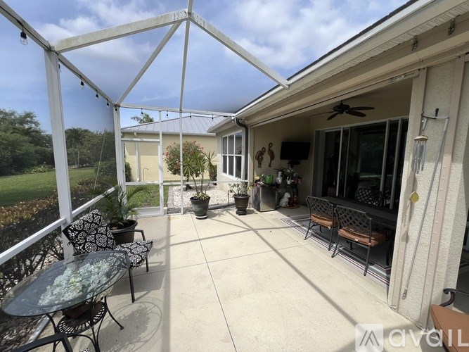A patio with a table and chairs is covered by a white awning.