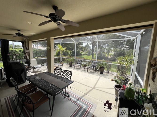 A patio with a table and chairs and a ceiling fan.