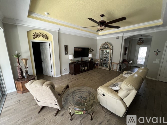 A living room with a beige sofa and a glass coffee table.