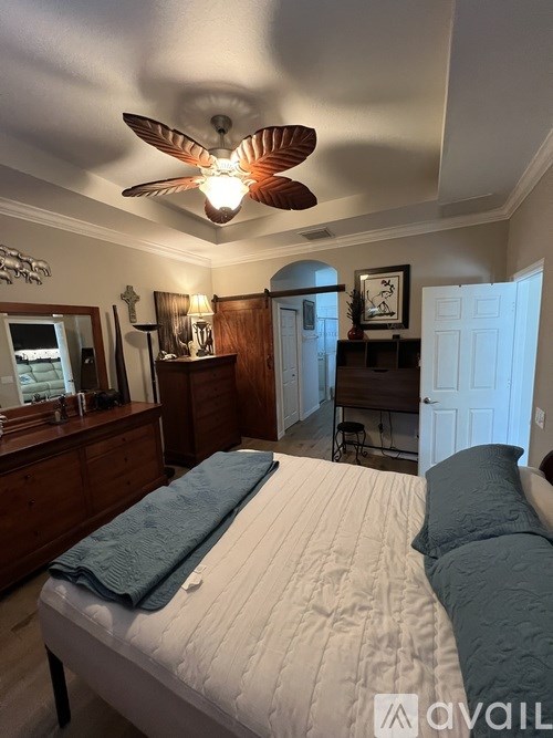 A bedroom with a bed, dresser, and mirror.