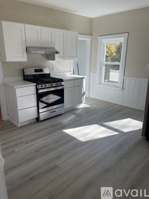 A kitchen with white cabinets and a black stove top oven.