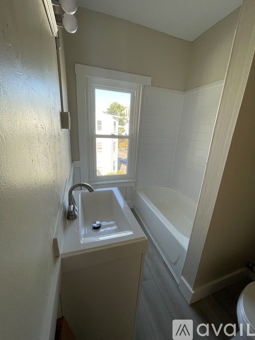 A bathroom with a window and a white sink.