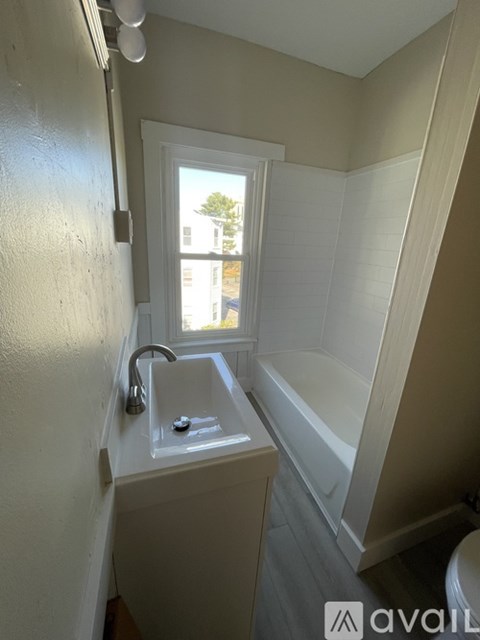 A bathroom with a window and a white sink.