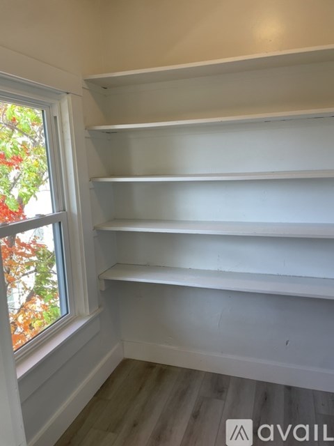 Empty white shelves in a room with a window.