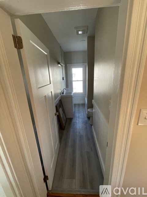 A hallway with a staircase leading to a second floor.