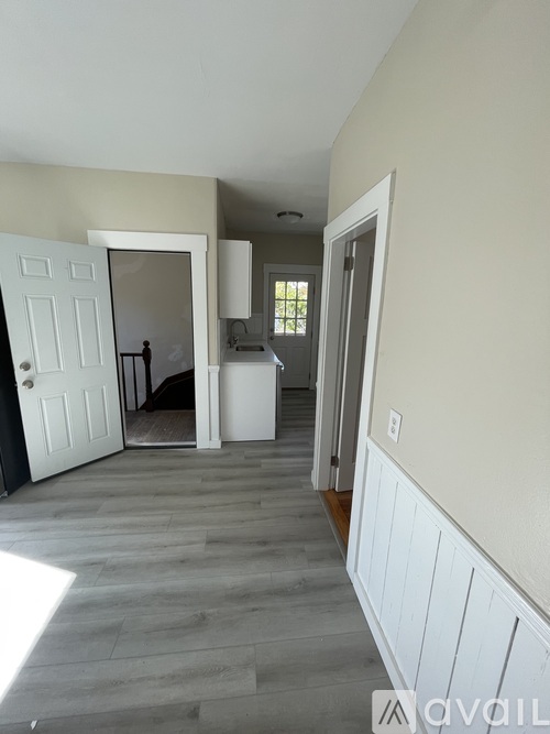A room with a white door and a grey floor.