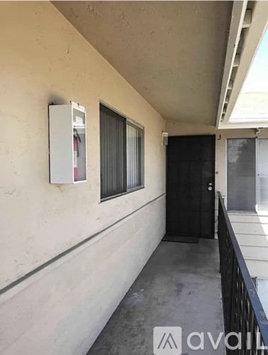 A white refrigerator is in the doorway of a building.