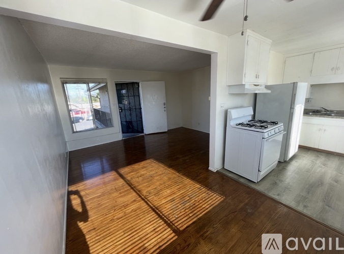 A kitchen area with a white fridge, stove, and cabinets.