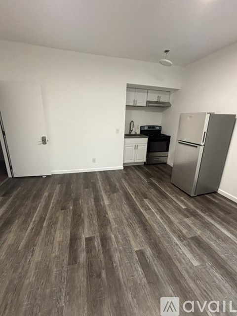 A kitchen area with a refrigerator, oven, and cabinets.