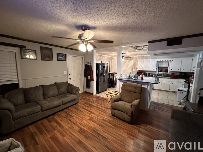 A living room with a brown couch and a brown recliner.