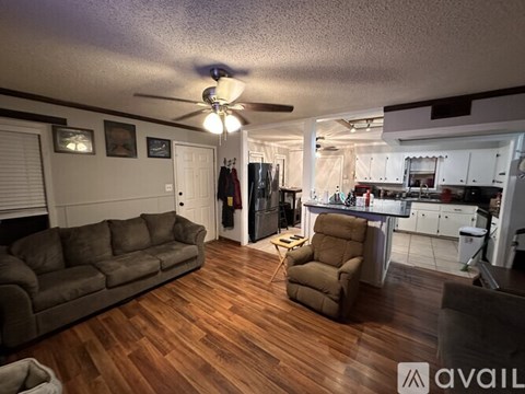 A living room with a brown couch and a brown recliner.