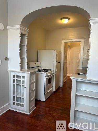 A kitchen with white appliances and cabinets.