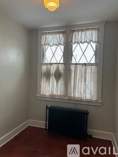 A room with a window and a radiator on the floor.