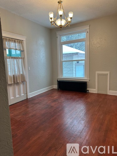 A room with wooden floors and a chandelier.