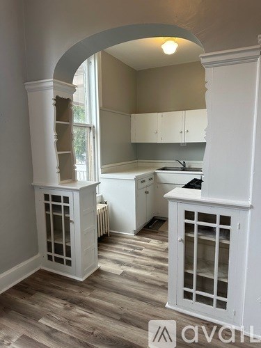 A kitchen with white cabinets and a window.