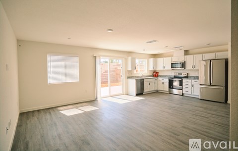 A spacious kitchen with white cabinets and stainless steel appliances.