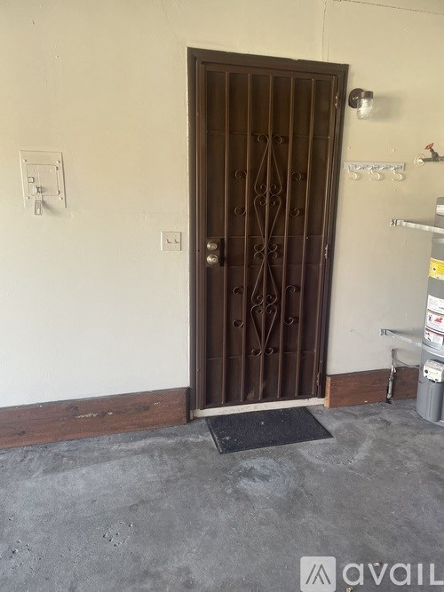 A brown door with a black mat in front of it.