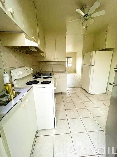 A kitchen with white appliances and cabinets.
