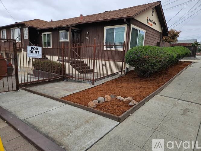 A house is for rent and has a brown fence.