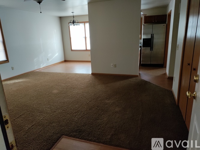 A room with a carpeted floor and a ceiling fan.