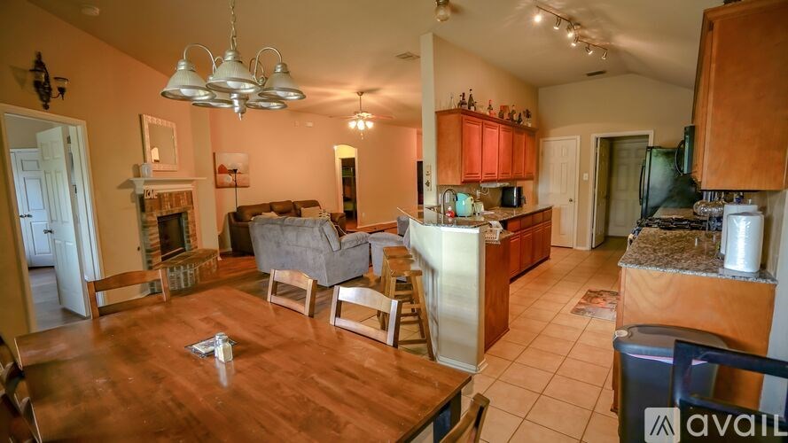 A kitchen with a dining table and chairs in the middle of the room.