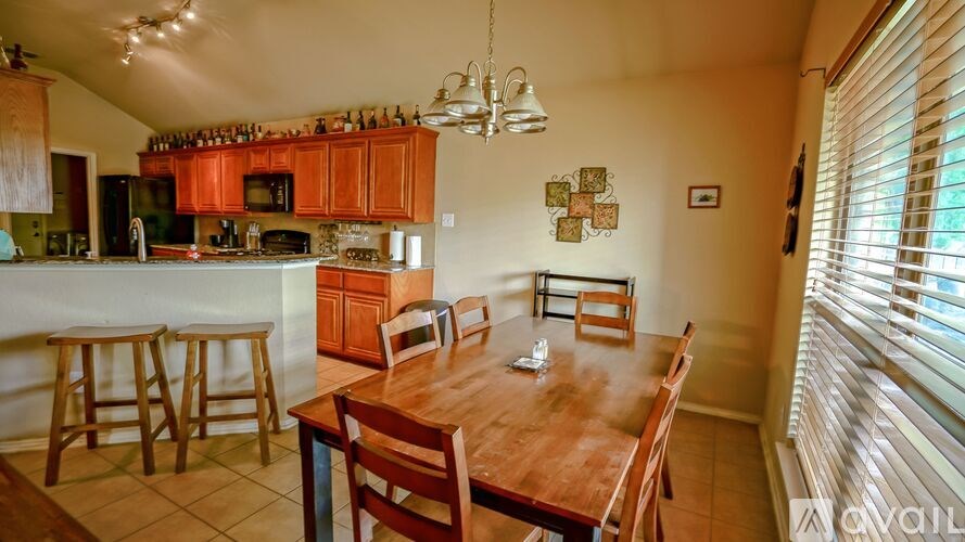 A kitchen with wooden cabinets and a dining table with chairs.