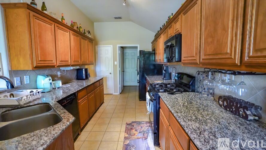 A kitchen with wooden cabinets and granite countertops.